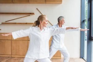 happy elderly couple practicing yoga together