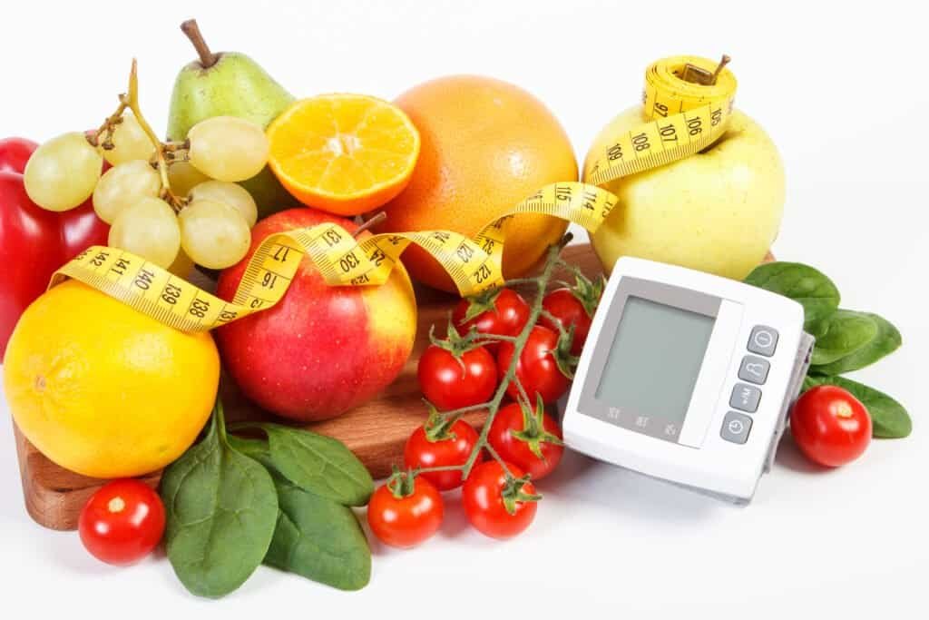Blood pressure monitor, fresh fruits with vegetables and tape measure, healthy lifestyle