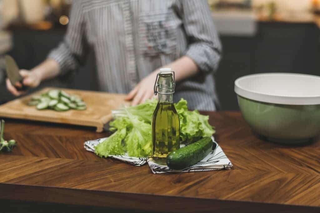 Young Woman Cooking in the kitchen. Healthy Food - Vegetable Salad. Diet. Dieting Concept. Healthy Lifestyle. Cooking At Home. Prepare Food