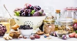 Balanced diet, cooking, vegetarian, raw and clean eating concept - close up of fresh organic fruits and vegetables, grains, legumes and nuts on concrete background with space for text